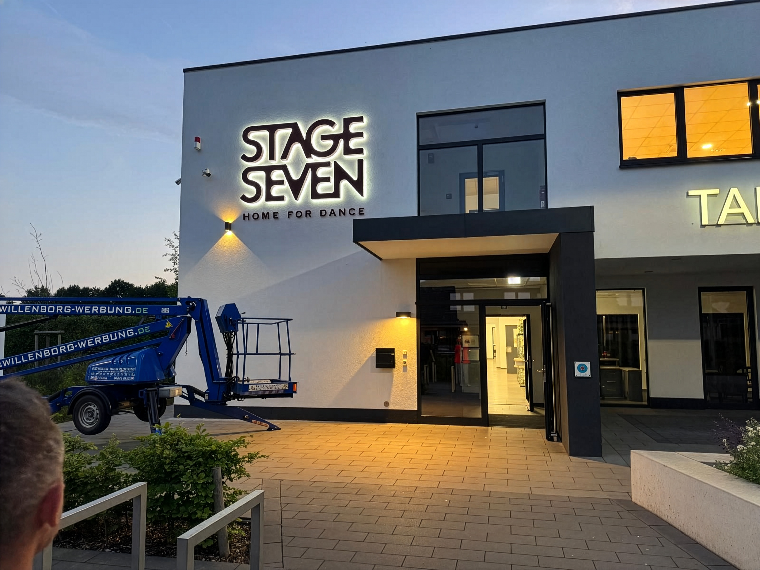 Beleuchtete Profilbuchstaben „Stage Seven“ bei Dämmerung, montiert von Willenborg Werbetechnik