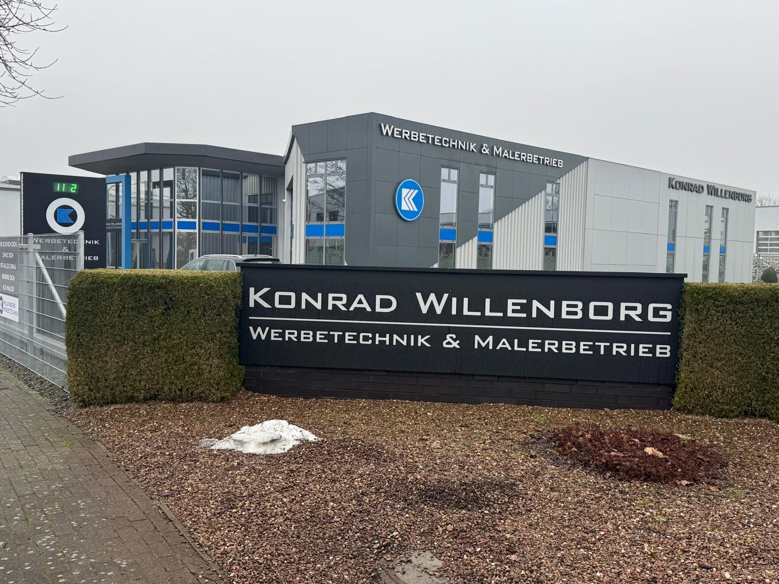 Firmenschild und Betriebsgebäude von Konrad Willenborg Werbetechnik & Malerbetrieb in Lohne